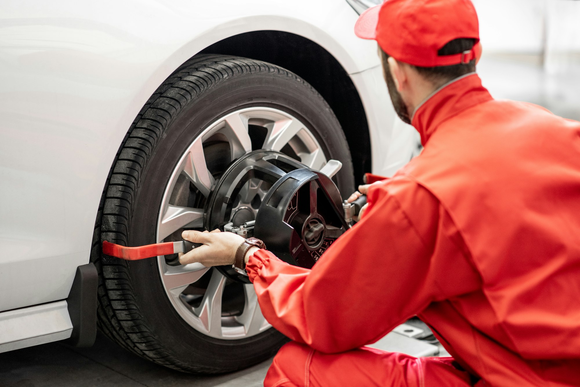 Auto mechanics making wheel alignment at the car service